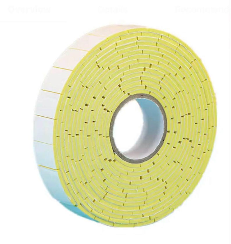 May include: A roll of yellow and white double-sided foam tape. The tape is rolled up, showing the layers of yellow foam and white adhesive backing. The roll has a cardboard core.