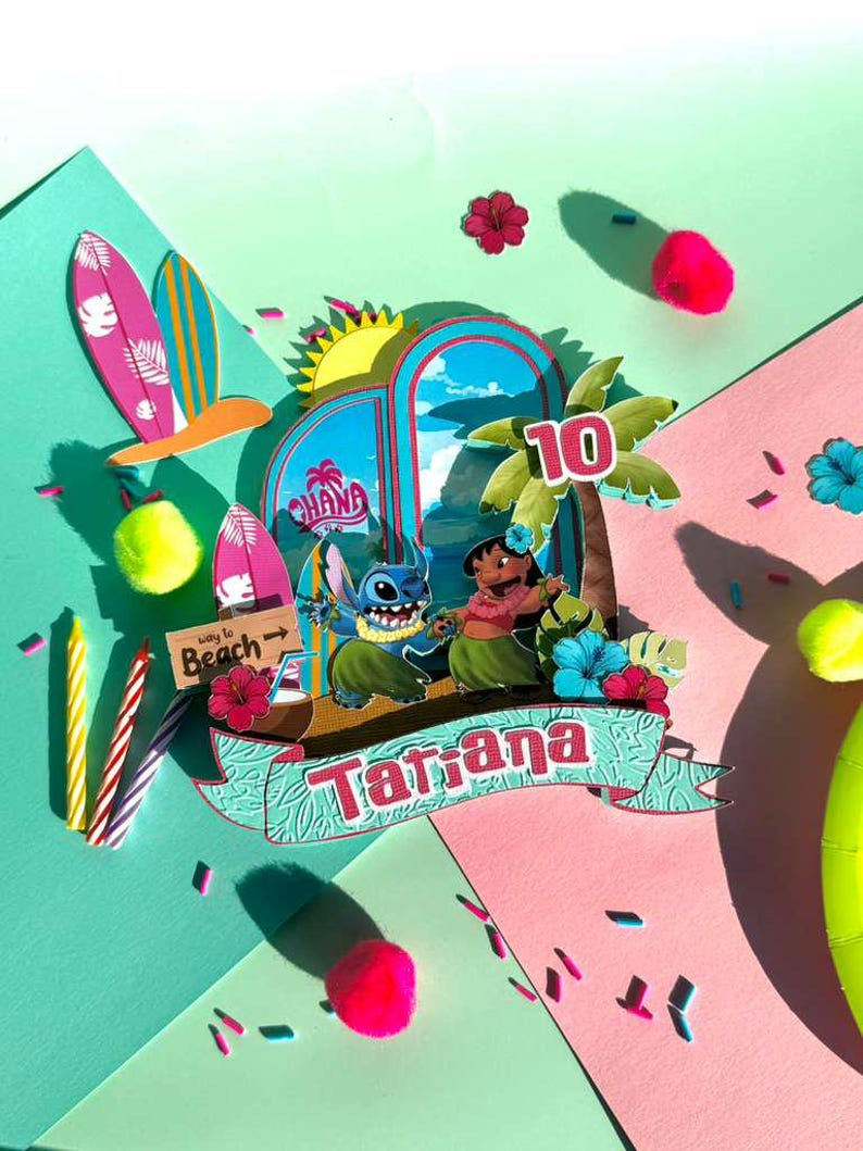 Puede incluir: Un adorno para tarta colorido con tem&aacute;tica tropical que presenta a los personajes Stitch y Lilo. El dise&ntilde;o incluye tablas de surf, palmeras y el nombre "Tatiana" con el n&uacute;mero 10. El fondo es una mezcla de rosa, verde y azul.