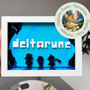 Könnte beinhalten: Ein gerahmtes Kunstwerk mit dem Wort "deltarune" in weißen Blockbuchstaben mit einem roten Herz. Der Hintergrund ist ein blaues, pixeliges Design mit drei Charaktersilhouetten. Ein runder Aufkleber mit einem Cartoon-Fuchs befindet sich oben rechts.