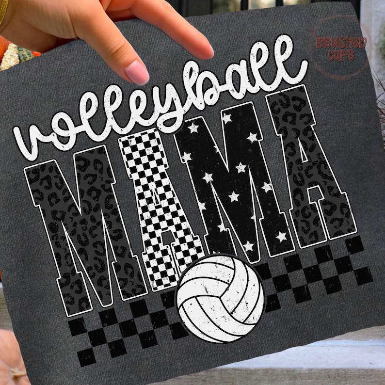 May include: Dark gray t-shirt with the words "Volleyball MAMA" in white script and block letters. The letter "M" features a checkered pattern, the "A"s have a leopard print, and the other letters have white stars. A volleyball graphic is at the bottom.