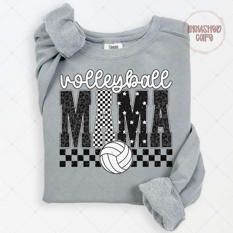 May include: A gray sweatshirt with the words "Volleyball Mama" in a mix of fonts and patterns. The word "Volleyball" is in a script font, and "MAMA" is in a bold font with leopard print, checkered, and star patterns. A white volleyball is at the bottom.