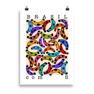 May include: A colorful poster with the word "BRASIL" at the top and "COM" and "S" at the bottom. The background is a light orange color and the poster is filled with colorful bananas with black polka dots.