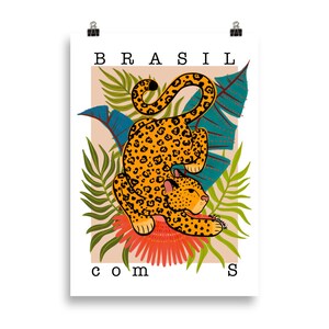 May include: A poster with the word "BRASIL" in large letters at the top and the word "com" at the bottom. A jaguar with orange and black spots is curled up in a jungle scene with green and blue leaves and a red flower.