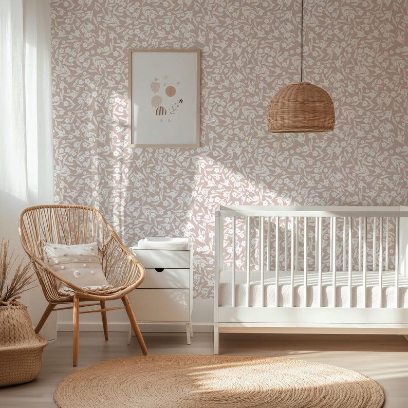 May include: A nursery interior with a white crib, a woven chair, and a round jute rug. The walls are covered in a floral wallpaper. A framed print hangs on the wall, and a woven pendant light hangs from the ceiling. The room is filled with natural light.