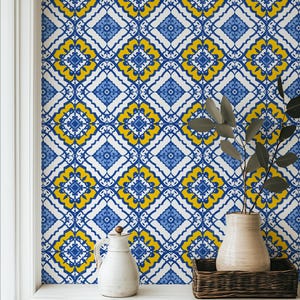 May include: A vibrant wallpaper featuring a repeating geometric pattern in shades of blue, yellow, and white. The design includes diamond shapes with floral-like motifs, creating a decorative and eye-catching backdrop. A white pitcher and vase sit on a white surface.