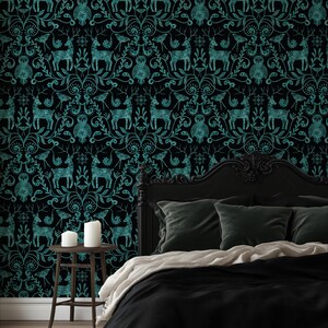 May include: Black wallpaper with a teal pattern of deer, owls, and floral elements. The design creates a gothic or vintage aesthetic, suitable for a bedroom or accent wall. The image also shows a bed with black bedding and green pillows.