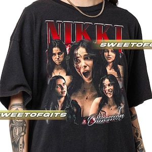 May include: A black short-sleeve t-shirt featuring a graphic print with the text NIKKI in red and white at the top and Obsession in white script at the bottom. The design includes five photographic portraits of a woman with various expressions.