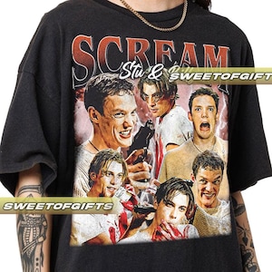 Könnte beinhalten: Schwarzes T-Shirt mit einem Grafikdruck von Charakteren aus dem Film Scream. Der Text "Scream" ist in Rot und der Text "Stu &" ist in Weiß. Der Grafikdruck zeigt die Charaktere aus dem Film in einem Collage-Stil.