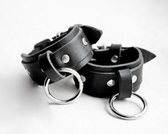 O-RING CUFF: Black leather cuff wristband with studs and buckle