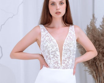 Vestido de novia estilo sirena, vestido de crepé color marfil, corpiño de encaje floral, silueta nupcial con espalda descubierta.