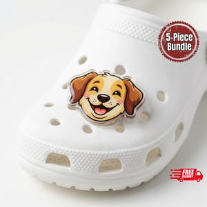 May include: A white Croc shoe with a smiling dog face charm. The charm features a happy dog with brown ears and a light brown and white face. A red and white "5-Piece Bundle" sticker is visible.