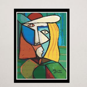 May include: Abstract art print featuring a cubist portrait in a black frame. The artwork showcases a face with geometric shapes in blue, white, yellow, red, and green. The artist's signature, "Picasso," is visible in the lower right corner.