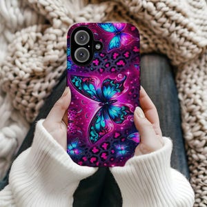 May include: A phone case featuring a vibrant butterfly design in shades of blue, pink, and purple. The case has a leopard print pattern and a glossy finish. The case is designed for a smartphone.