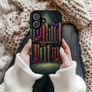 Op de afbeelding: Zwarte telefoonhoes met een gedetailleerde illustratie van een boekenplank. Het ontwerp toont kleurrijke boeken, bloemen en wijnranken, met een vintage, fantasie esthetiek. De hoes heeft een uitsparing voor een camera met dubbele lens.
