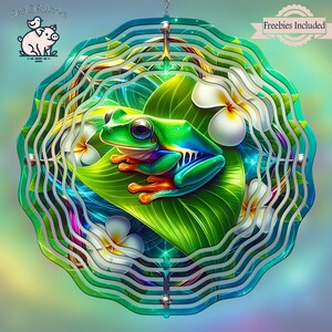 May include: A colorful metal wind spinner with a green frog sitting on a leaf with white flowers. The wind spinner has multiple layers of metal that spin in the wind.