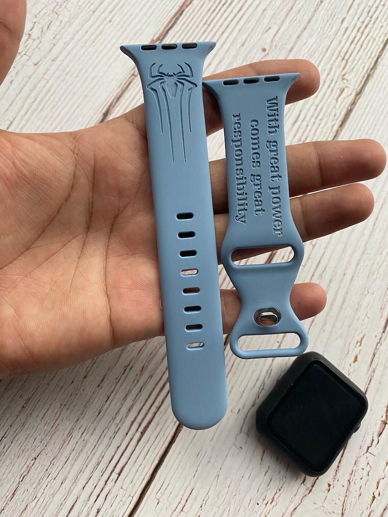 May include: Two light blue silicone watch bands with a Spiderman graphic and the text "With great power comes great responsibility".