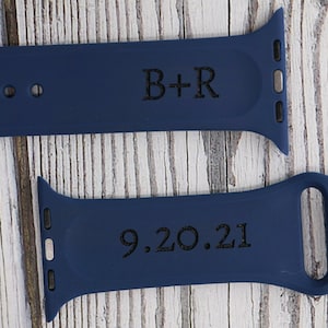 May include: Two navy blue silicone Apple Watch bands with black engraved text. The top band reads "B+R" and the bottom band reads "9.20.21".