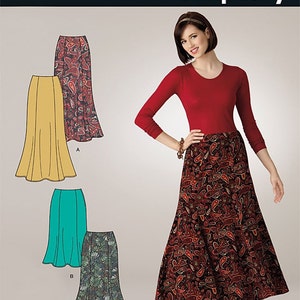 May include: A sewing pattern for a skirt with three different styles. The pattern is called "Simplicity" and the number is 2312. The skirt styles include a solid yellow skirt, a solid teal skirt, and a patterned skirt with a paisley design. The pattern is labeled "It's so easy".