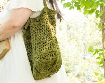 May include: A green crocheted tote bag with a large open weave pattern. The bag is being worn by a person in a white dress.