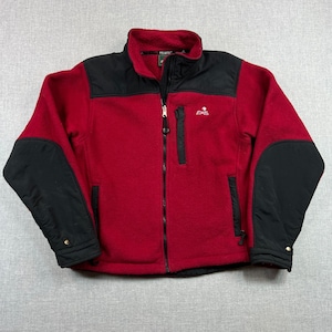 May include: A red fleece jacket with black accents on the shoulders and sleeves. The jacket has a full-length zipper, a stand-up collar, and two zippered pockets. The brand logo "EMS" is embroidered on the chest.