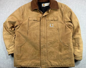 May include: A tan work jacket with a brown corduroy collar. The jacket has two chest pockets, two lower pockets, and a Carhartt logo patch. The jacket is a medium size.