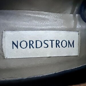 Puede incluir: Una etiqueta blanca con la palabra "Nordstrom" impresa en letras negras.