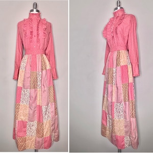 May include: A pink long-sleeved dress with a ruffled collar and a patchwork skirt. The skirt is made of different floral and geometric patterns in shades of pink, cream, and brown.