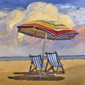 May include: Two striped beach chairs sit under a colorful striped umbrella on a sandy beach. The sky is blue with a large white cloud.
