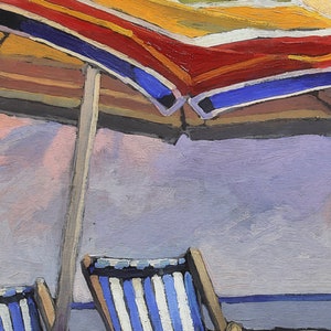 May include: A striped beach chair with a blue and white pattern sits under a red, yellow, and blue striped beach umbrella. The umbrella is partially open and the chair is facing away from the viewer.