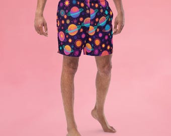 May include: A pair of black swim trunks with a colorful pattern of planets and stars. The trunks have an elastic waistband and a drawstring.