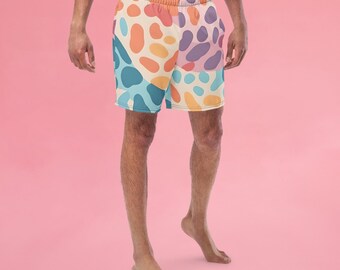 May include: A pair of colorful patterned swim trunks with a light blue, orange, pink, and yellow abstract design. The trunks have an elastic waistband and a drawstring.