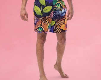 May include: A pair of colorful swim trunks with a repeating pattern of green leaves and orange and black cat faces. The cat faces have green eyes and white whiskers.