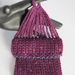 May include: A small, purple crocheted bag with a blue beaded trim. The bag has a long, crocheted strap that can be used to carry it.