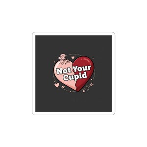 May include: A sticker with a dark grey background. It features a two-tone heart design, with a pink left side and a red right side. The text "Not Your Cupid" is in the centre, with a small cupid and hearts.