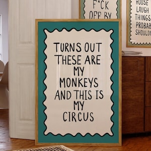 Puede incluir: Tres impresiones artísticas enmarcadas con citas humorísticas. La impresión más grande dice "TURNS OUT THESE ARE MY MONKEYS AND THIS IS MY CIRCUS." Las otras dos impresiones tienen frases ingeniosas similares. Los marcos tienen un borde turquesa.
