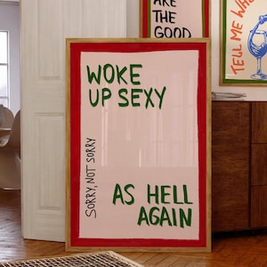Puede incluir: Tres impresiones enmarcadas con texto motivacional. La primera impresión es rosa con texto verde que dice "These are the good". La segunda impresión es rosa con texto verde que dice "Woke up sexy as hell again" y tiene el texto "Sorry, not sorry" escrito verticalmente en el lado izquierdo. La tercera impresión es blanca con texto azul que dice "Tell me when..." y representa una copa de vino con una botella que vierte vino en la copa.