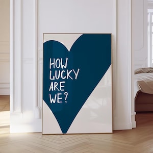 Könnte beinhalten: Eine blaue herzförmige Grafik mit dem Text "How lucky are we?" in Weiß auf weißem Hintergrund.