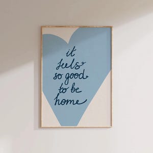May include: A blue and white heart-shaped print with the text "it feels so good to be home".