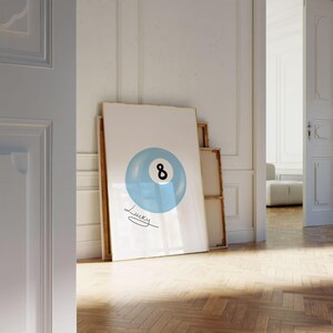 May include: A white poster with a blue and black 8-ball illustration. The text "Lucky" is written in cursive below the ball.