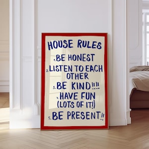 Può includere: Una stampa da parete rettangolare con sfondo color crema e un bordo rosso acceso. Il testo HOUSE RULES è stampato in blu, seguito da cinque punti numerati: 1. BE HONEST, 2. LISTEN TO EACH OTHER, 3. BE KIND!!!!, 4. HAVE FUN (LOTS OF IT!), 5. BE PRESENT!!