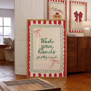 May include: Three framed art prints with a festive theme. The largest print reads "Wash your hands ya filthy animal" in green script. Two smaller prints feature a pig in sunglasses and a red bow. All prints have a red and white striped border.