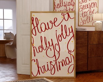 Puede incluir: Tres impresiones artísticas enmarcadas con temática navideña. La impresión más grande dice "Have a holly jolly Christmas" en escritura roja con estrellas doradas. Las otras dos impresiones tienen un texto similar en escritura roja. Todas están en marcos de madera clara.