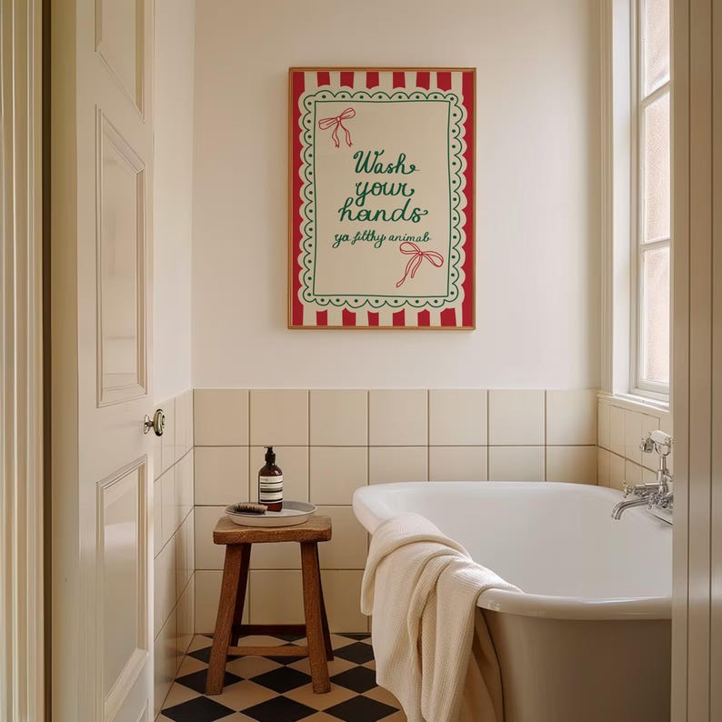 May include: A bathroom scene featuring a framed sign with the text "Wash your hands ya filthy animals." The sign has a red and white striped border and green accents. A wooden stool holds a soap bottle and brush. A white bathtub is in the background.