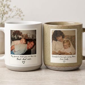 Könnte beinhalten: Zwei Keramikbecher mit Familienfotos. Ein Becher ist weiß mit grauem Boden und einem Foto von Vater und Kind. Der Text lautet "My favorite child gave me this mug. Best dad ever." Der andere Becher ist gesprenkelt mit einem Foto von Mutter und Kind. Der Text lautet "Grateful to have you as my Mom. Love, Emily."