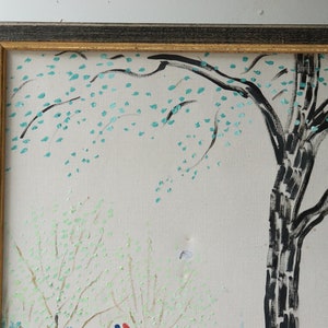 May include: A framed painting depicting a stylized landscape with a large tree in the center. The tree has a black trunk and branches with green leaves. The background is a light gray with hints of green and white.