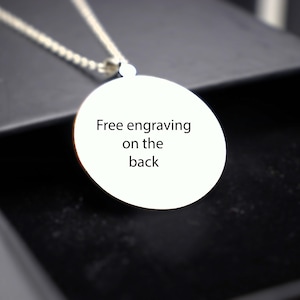 May include: A silver necklace with a round pendant that says "Free engraving on the back".