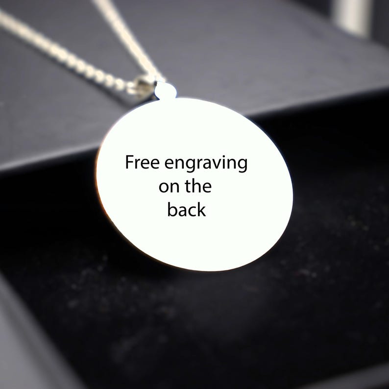 May include: A silver necklace with a round pendant that says "Free engraving on the back".