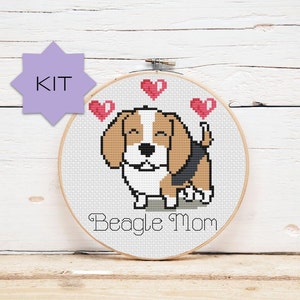 May include: Cross stitch pattern kit featuring a cartoon beagle dog with hearts around its head. The pattern is titled "Beagle Mom".