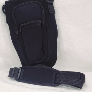 May include: Black neoprene insulated bottle holder with a zippered pocket and an adjustable shoulder strap.