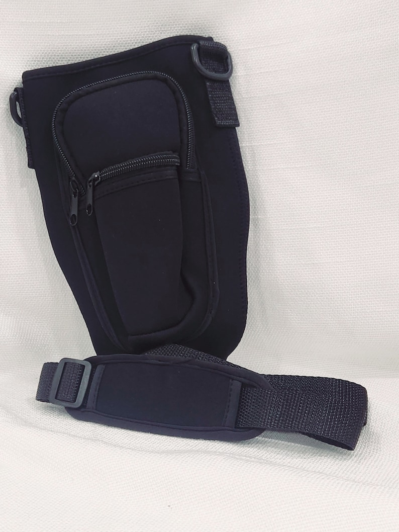 May include: Black neoprene insulated bottle holder with a zippered pocket and an adjustable shoulder strap.